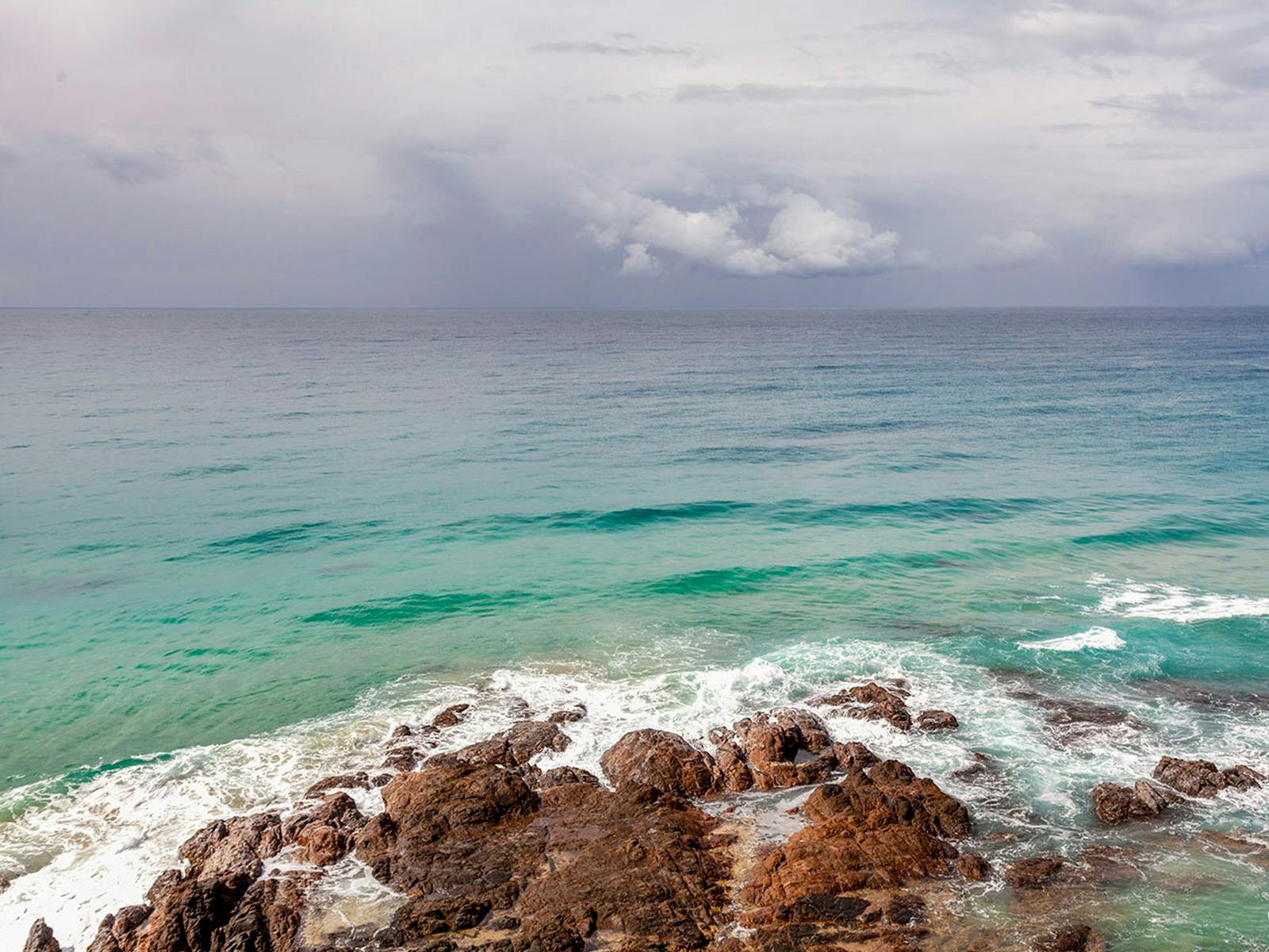 The calm ocean reflects the edge of the storm cloud atPoint Perry