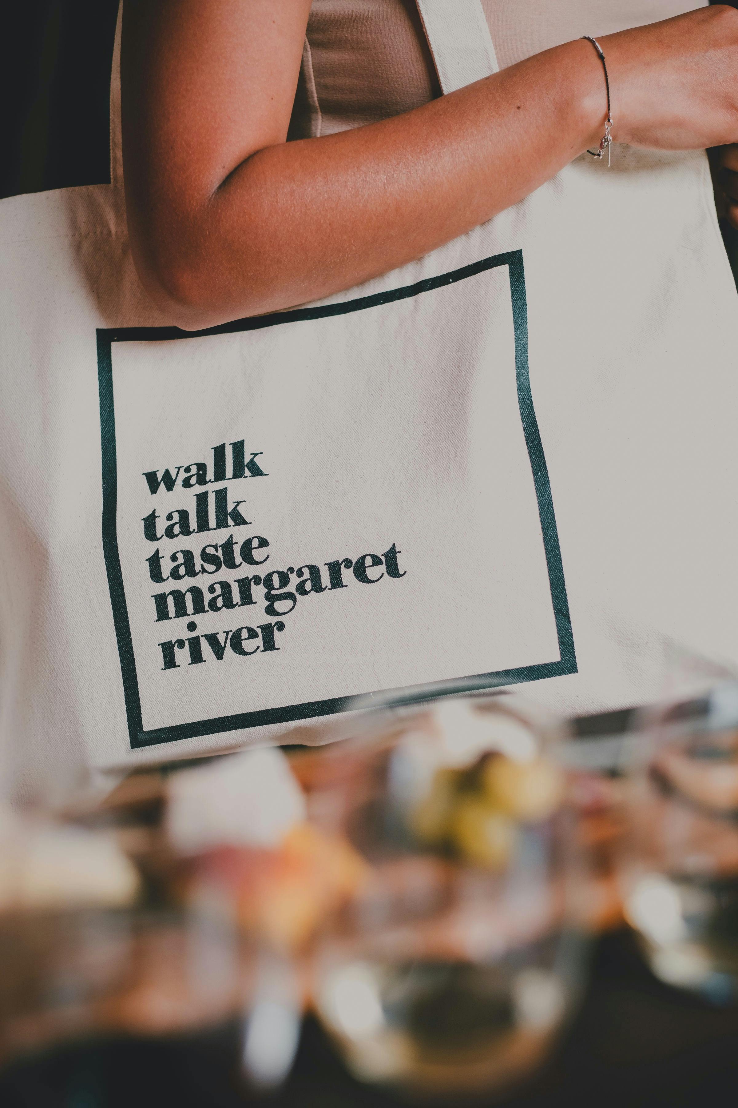 A tour guest carries their branded reusable shopping bag