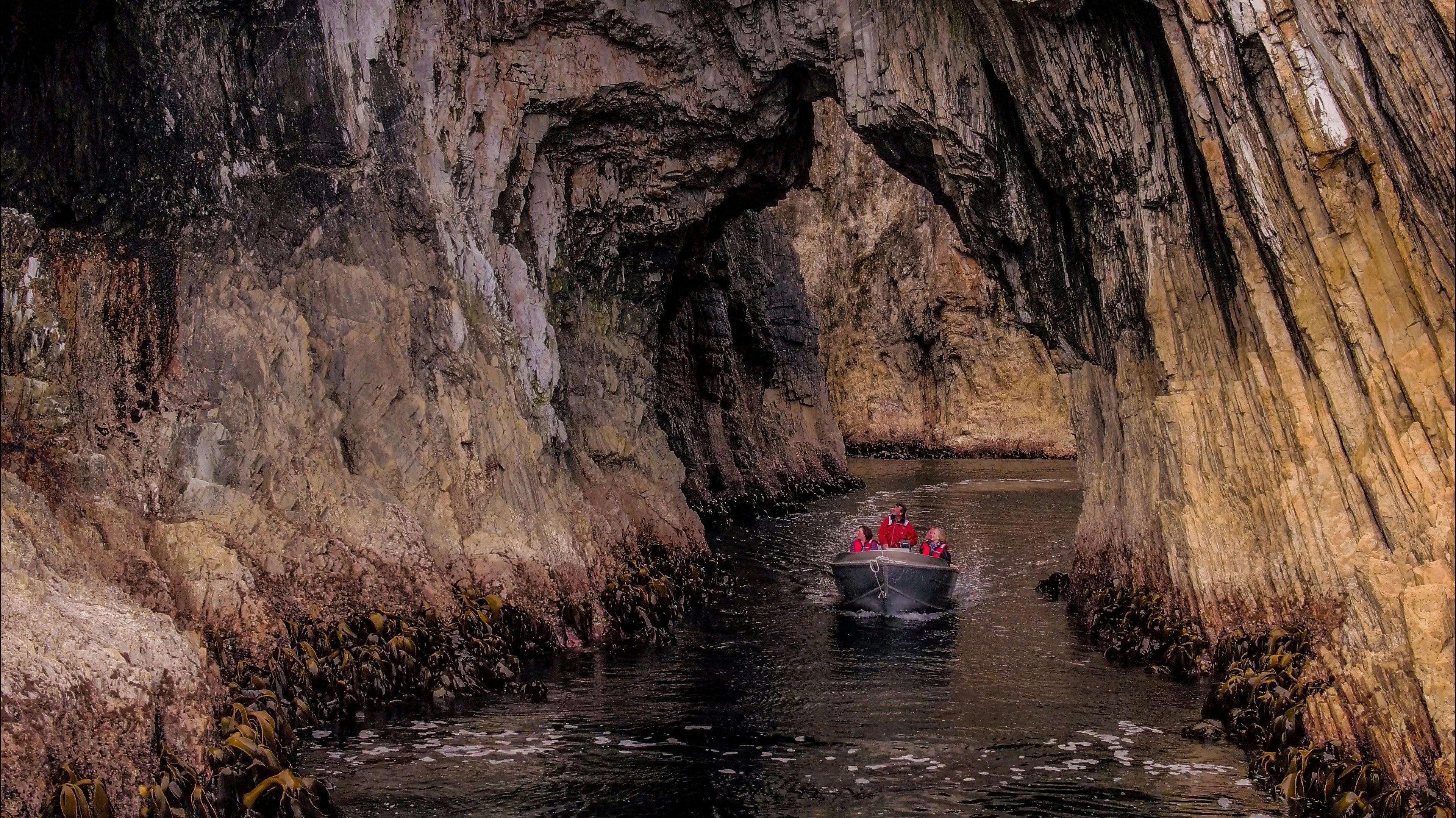 A group of people in a small boat, navigating through a cave
