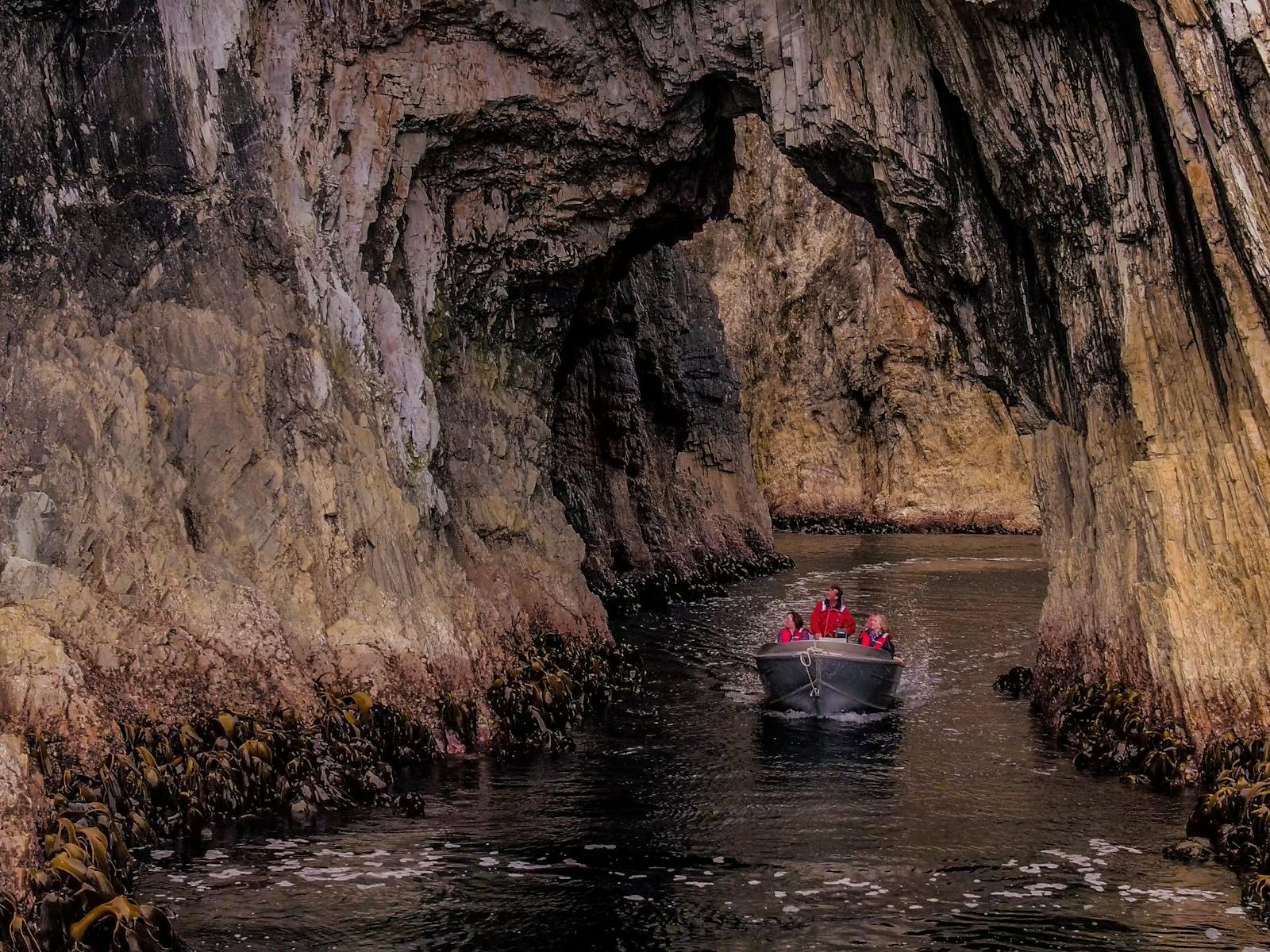 A group of people in a small boat, navigating through a cave