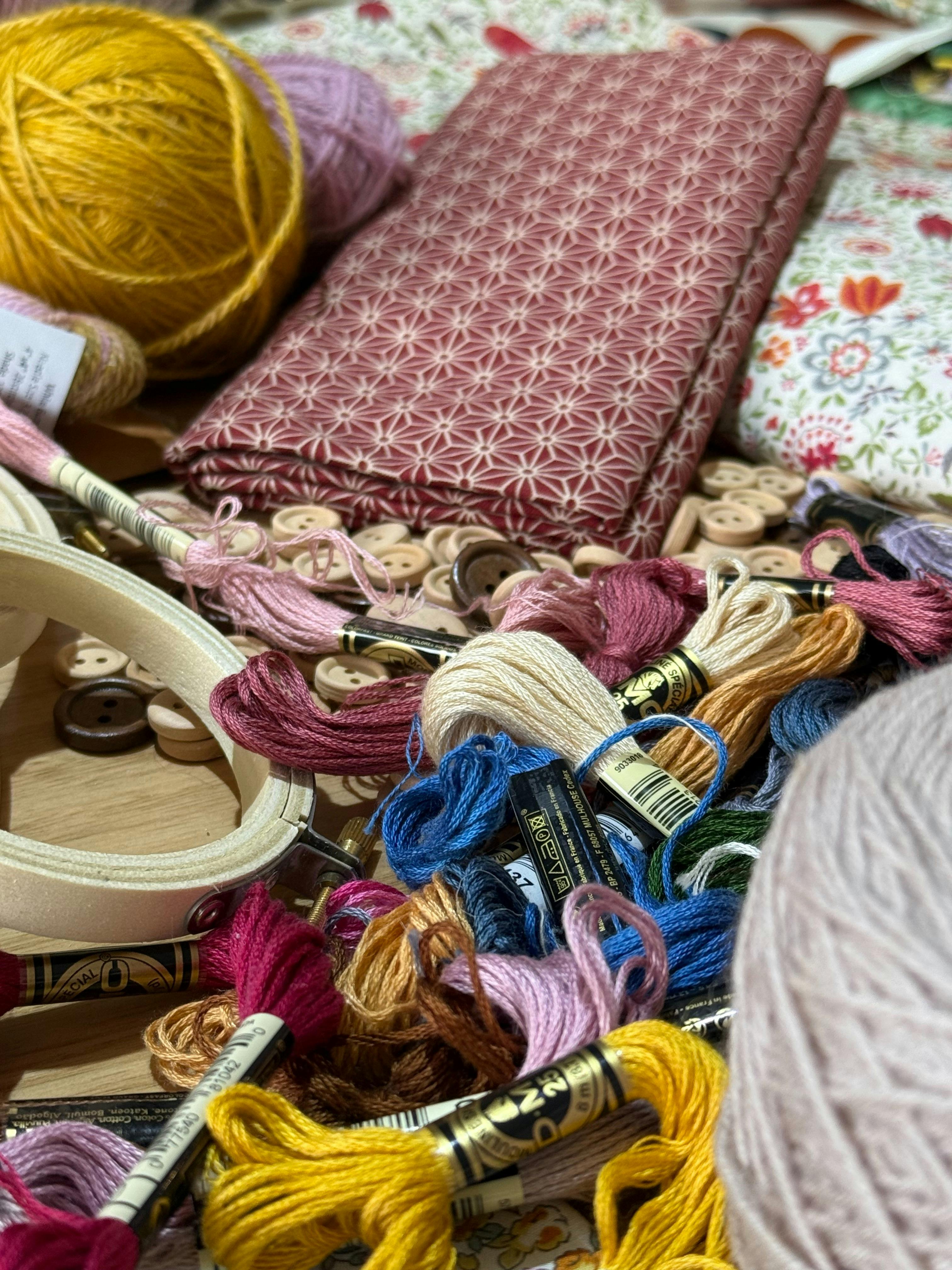 Embroidery threads, hooks, and fabric on a table
