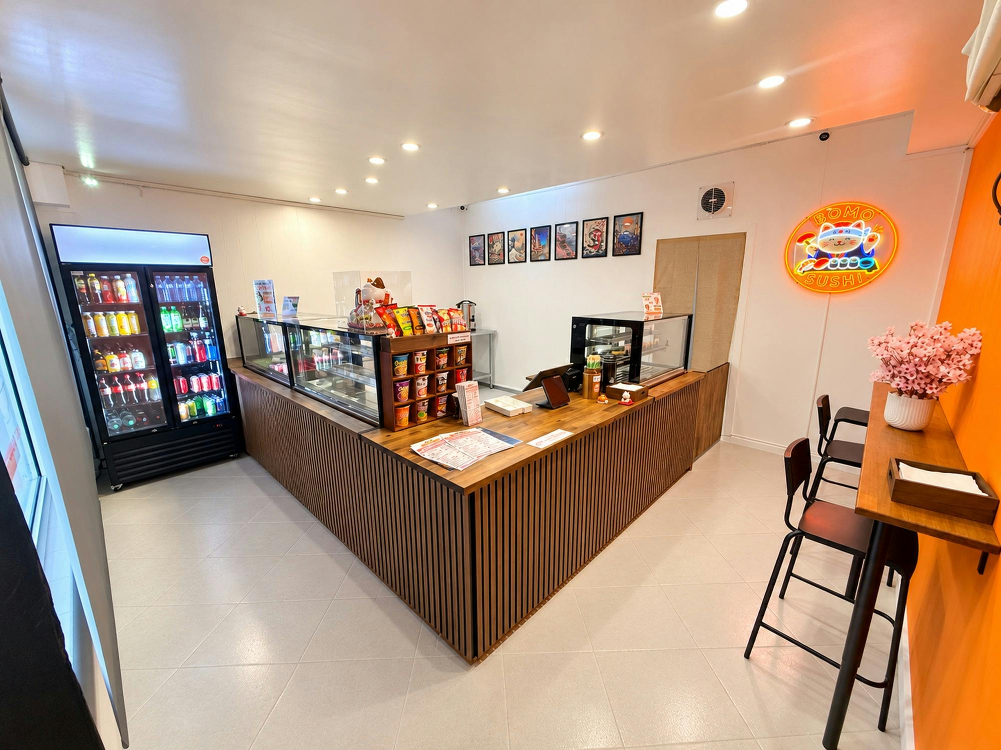 Wooden service counter, glass food displays, drinks fridge, seating & our iconic cat logo
