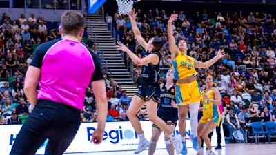 UC Capitals player driving to the basket for a layup during a WNBL game.