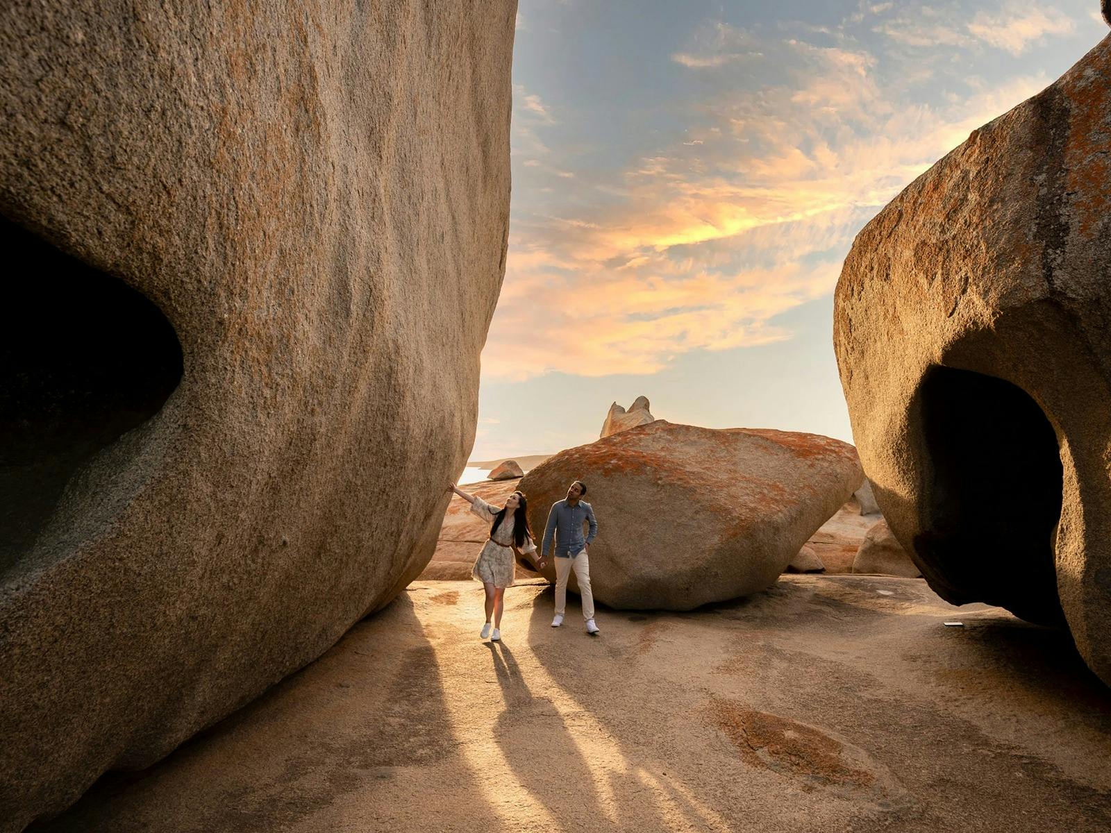 Two people walk amongst the Remarkable Rocks at Flinders Chase National Park