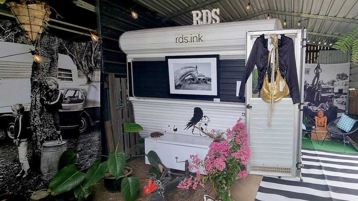 black and white caravan parked in shed with large black and white photos of the 70's