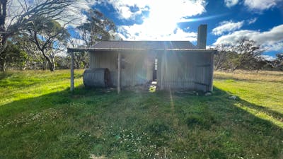 A hut with the sun setting being it.
