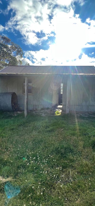 A hut with the sun setting being it.