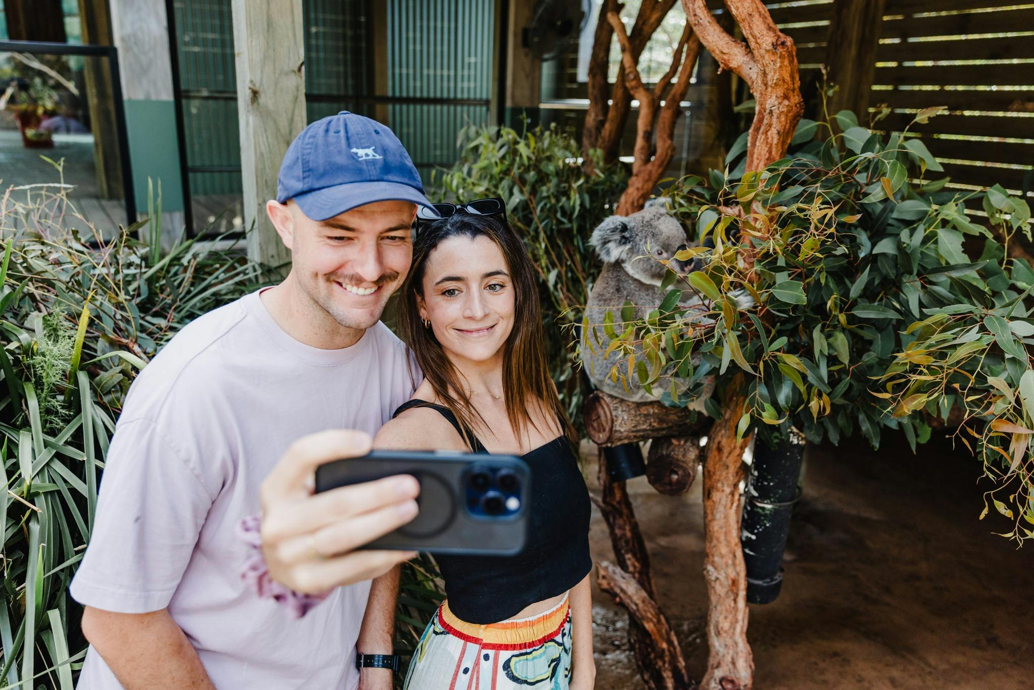 A couple taking a selfie with a Koala at Symbio Wildlife Park