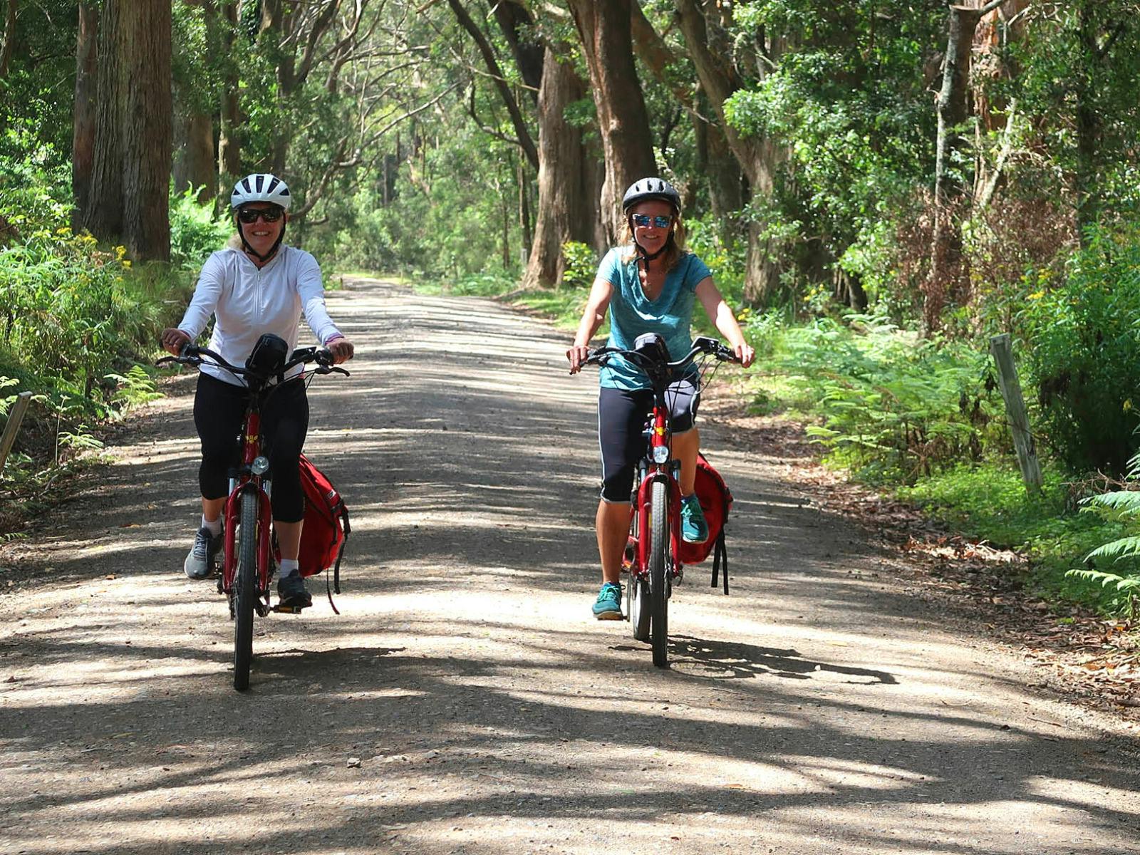 Cyclists on a dirt road leading to the Belmore Falls.