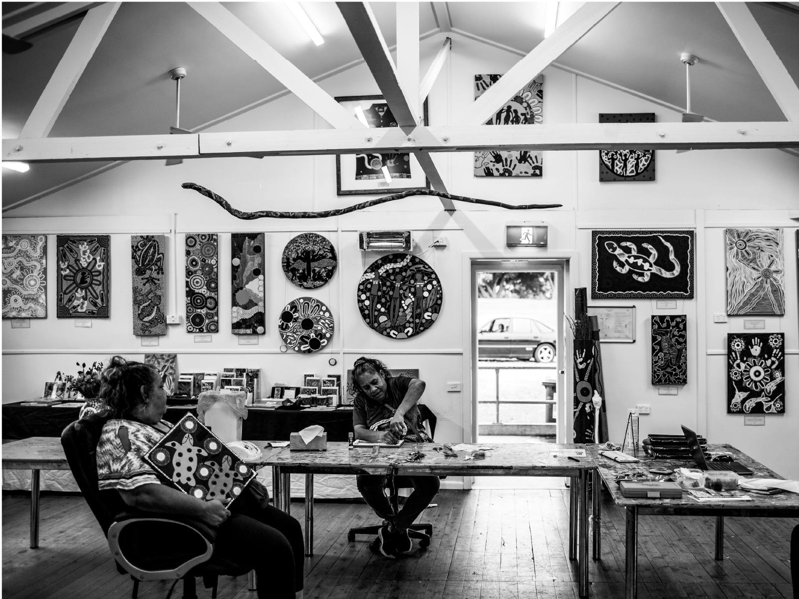 Black and white image of two people in an art gallery space