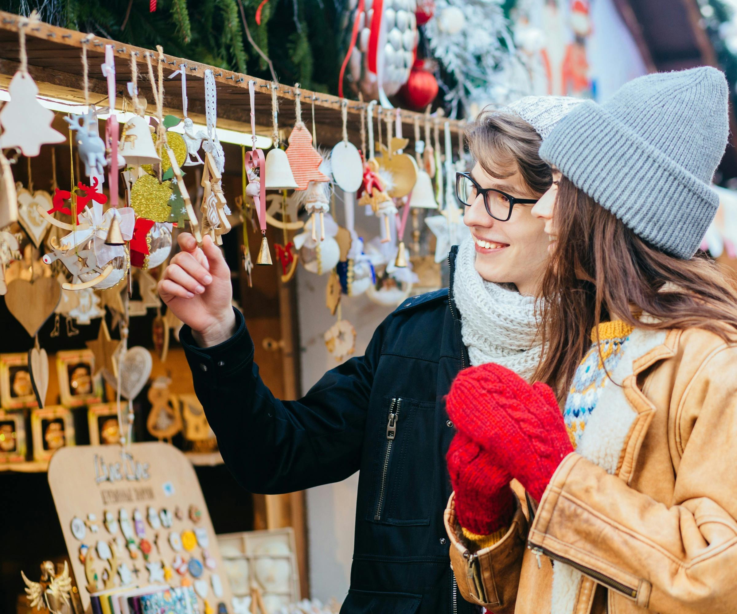 A couple shopping at a Christmas market stall.