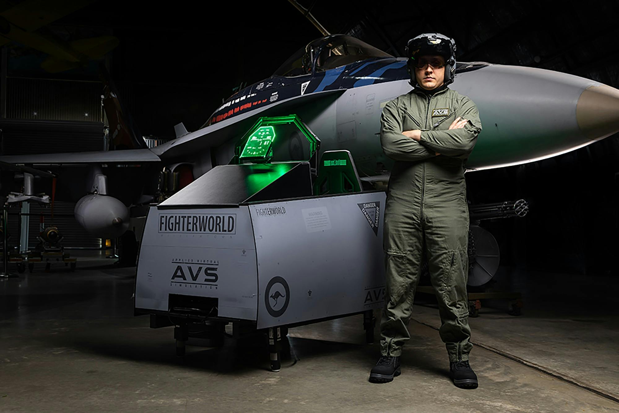 AVS Flight Simulator cockpit in front of an F/A-18 aircraft on display.