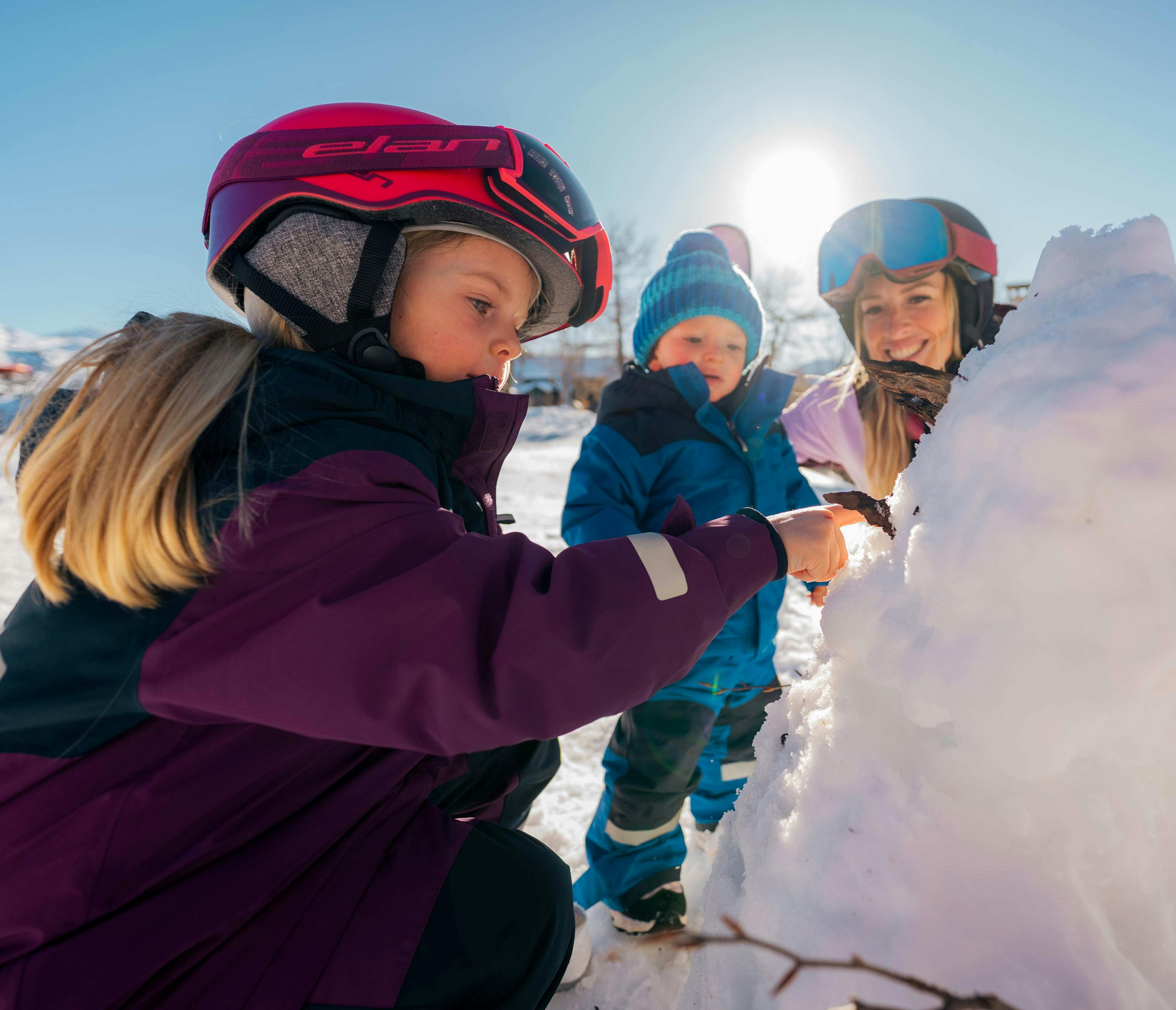 Mum & 2 kids building a snowman