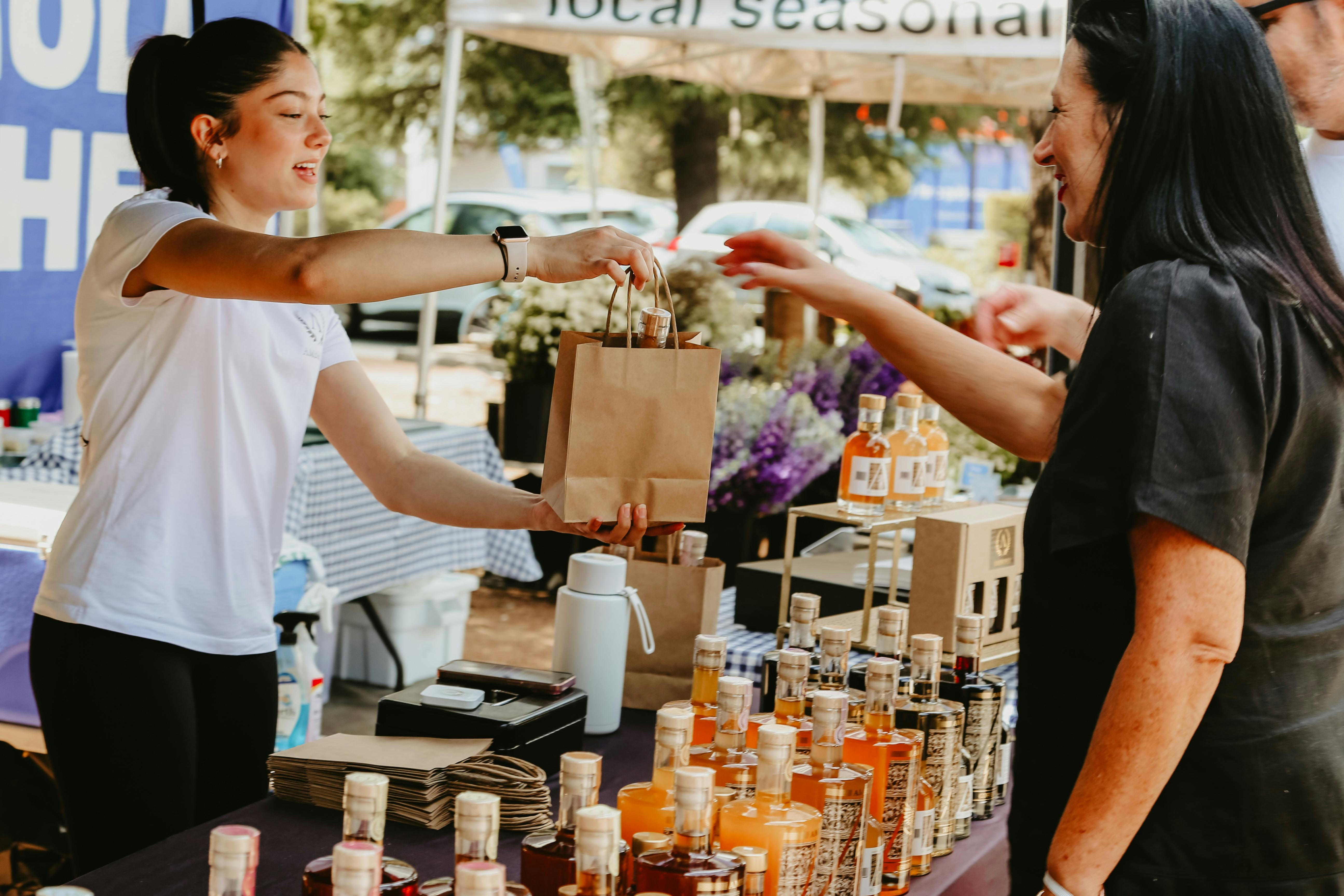 An image of a stallholder handing over a paper bag to a customer