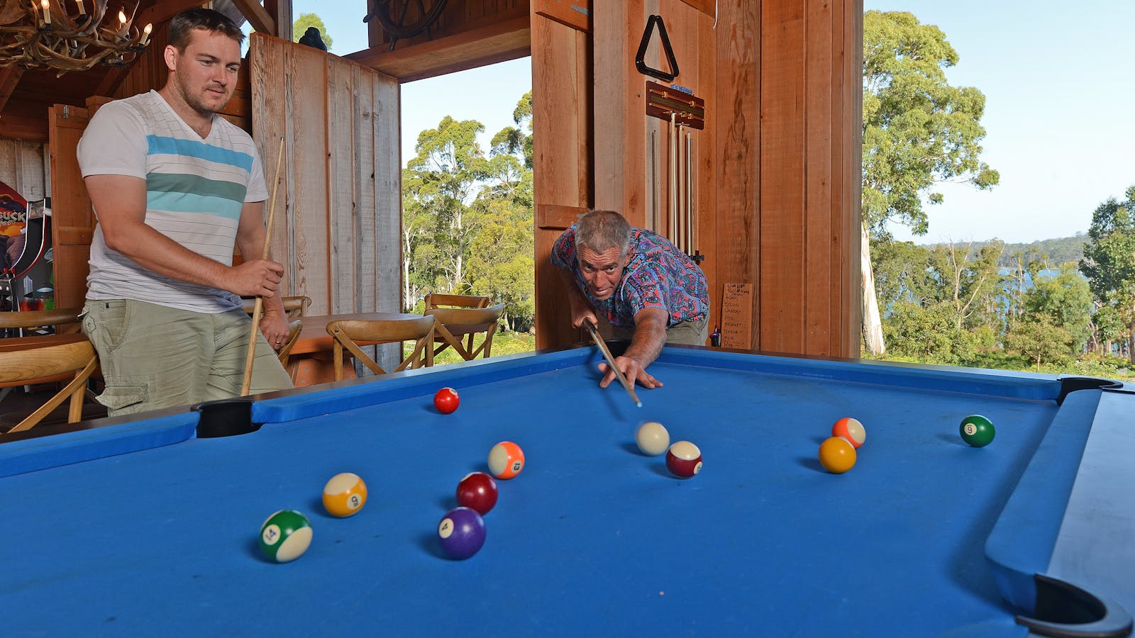 Playing pool at Bruny Island Lodge with view out to Mickeys Bay