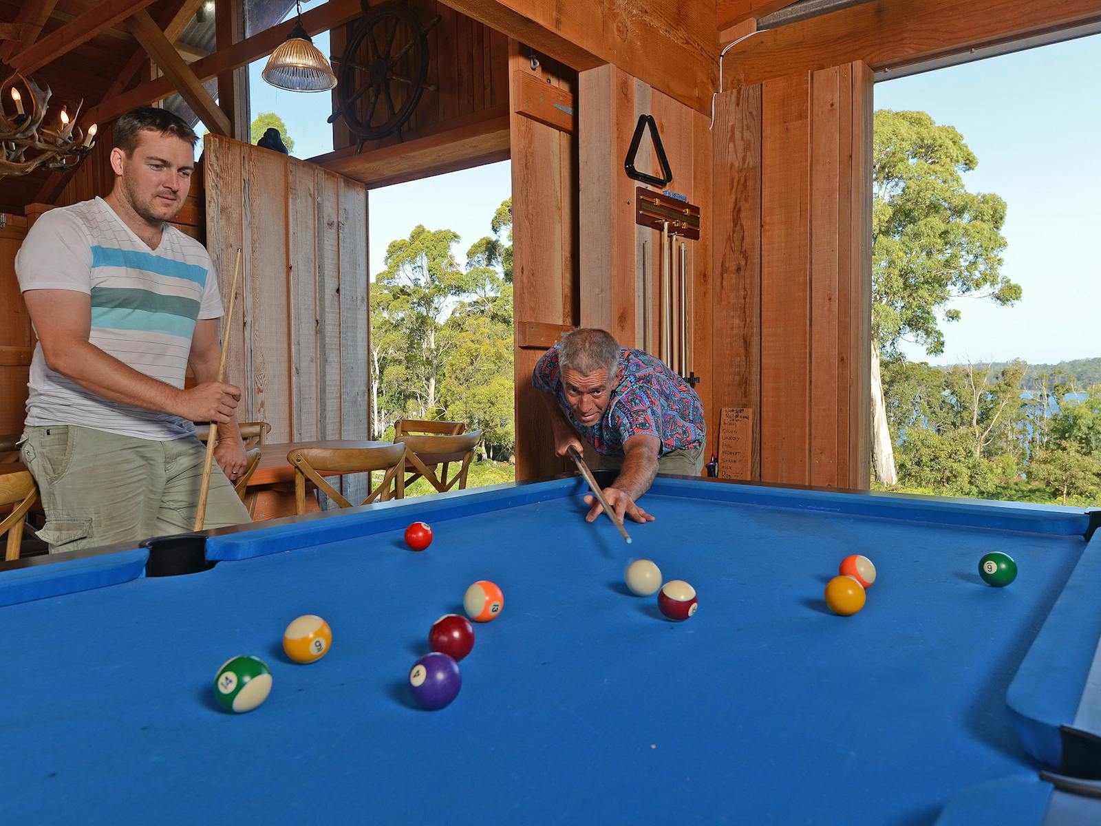 Playing pool at Bruny Island Lodge with view out to Mickeys Bay