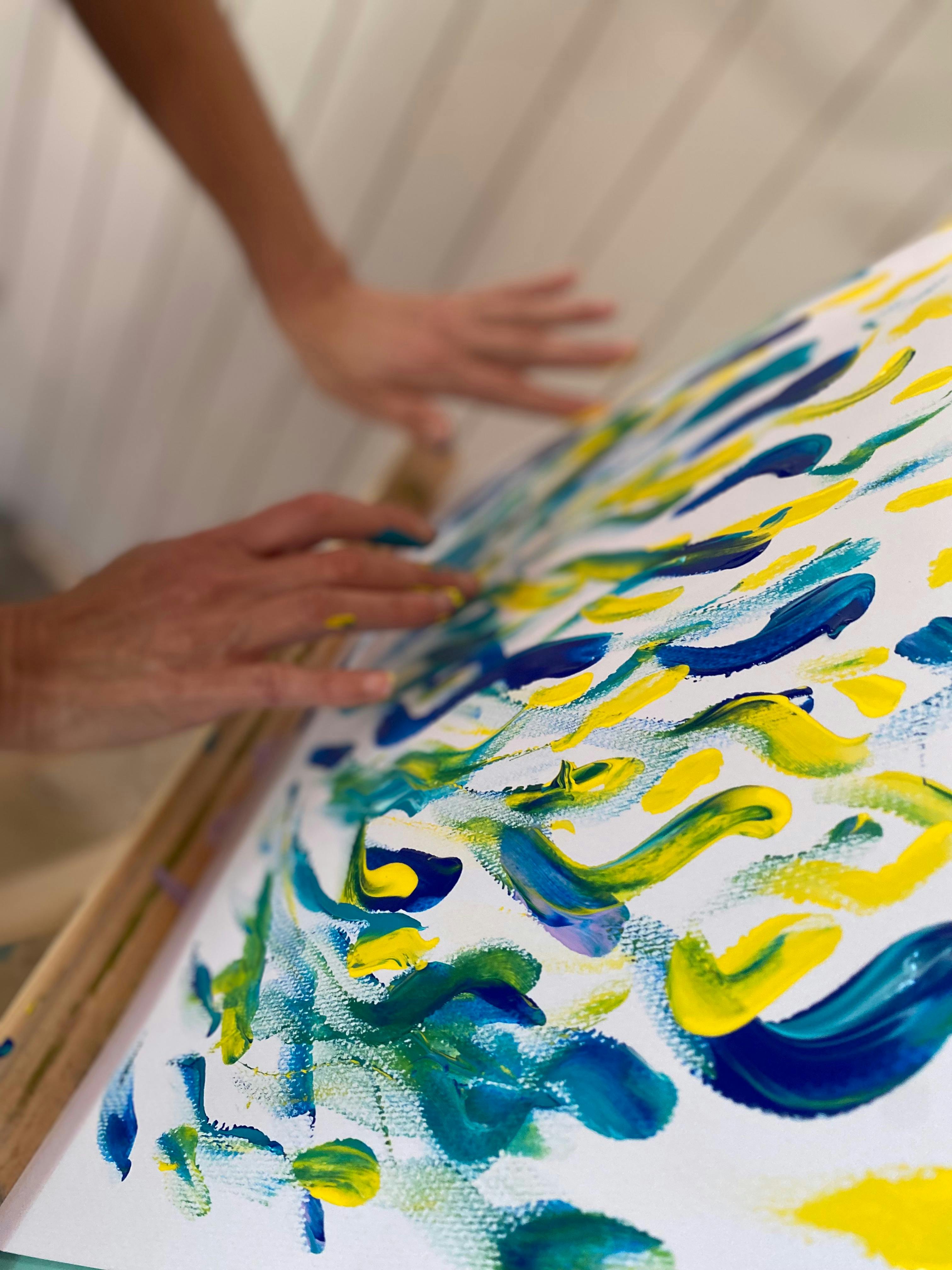 Art on an easel - painted with blue and yellow - with fingers