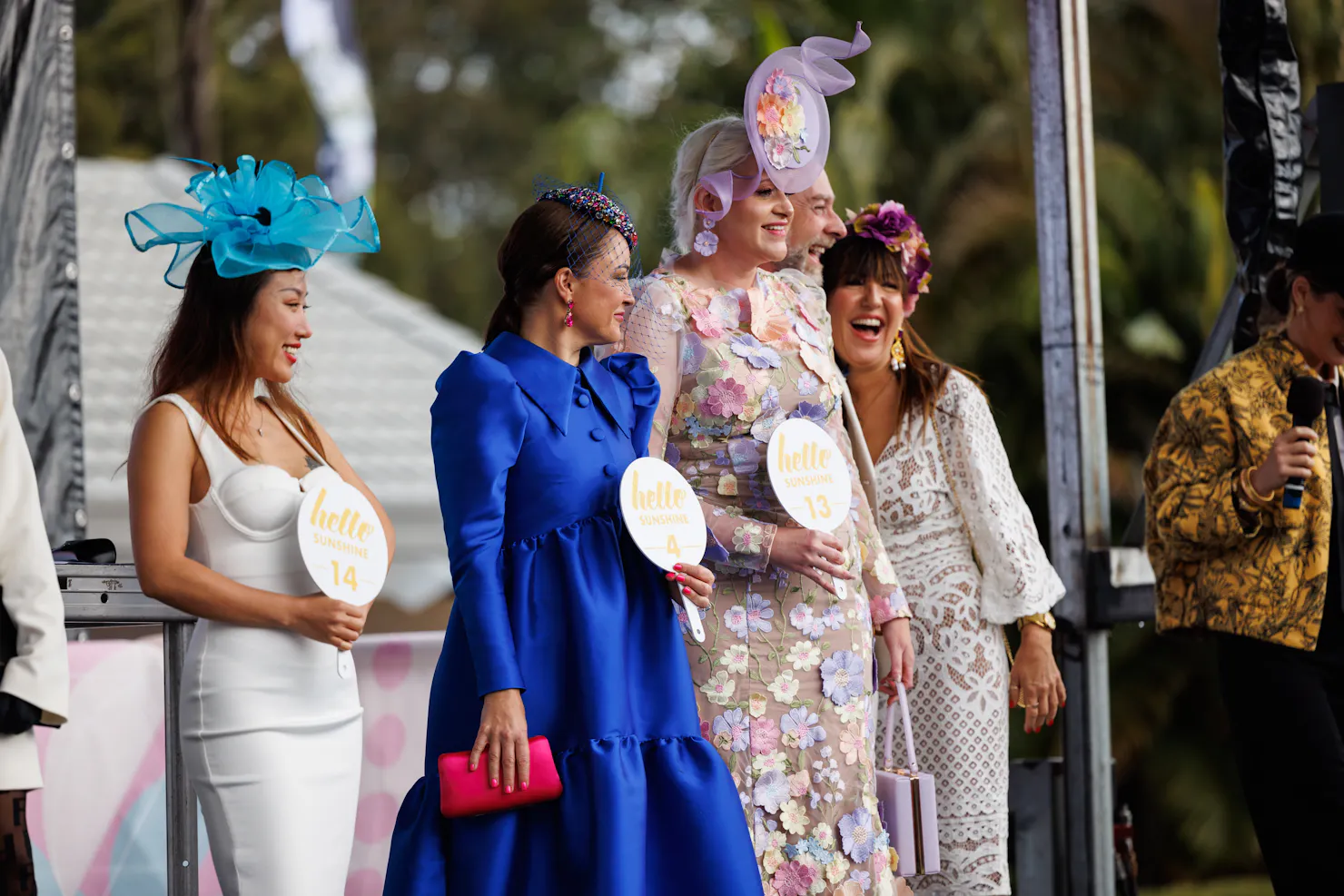 four females lining up on stage in dresses for fashions on the field