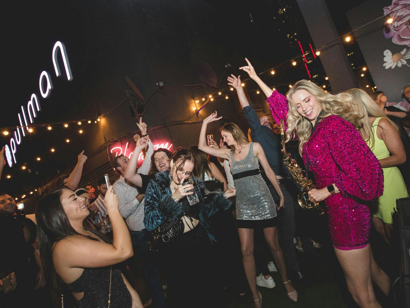 a group of people dancing on the dancefloor of Blossom Rooftop Bar