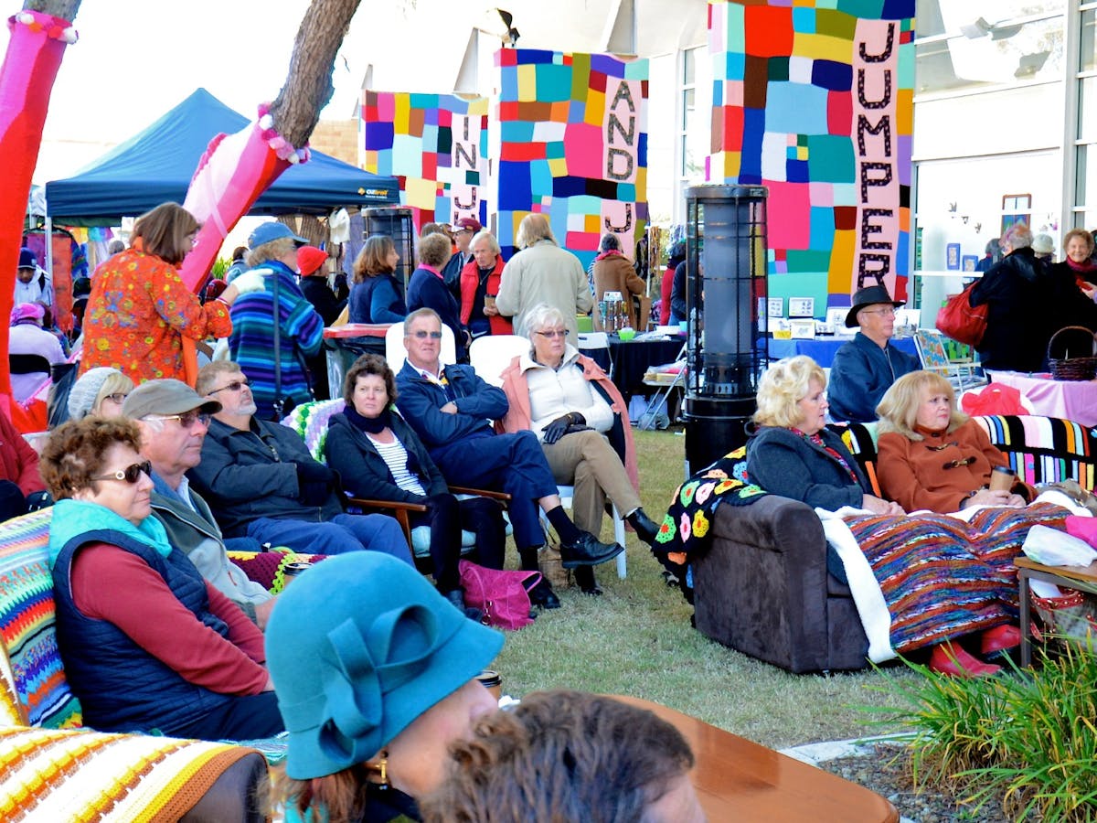 A market scene with people sitting on sofas outside A market scene with people sitting on sofas outside