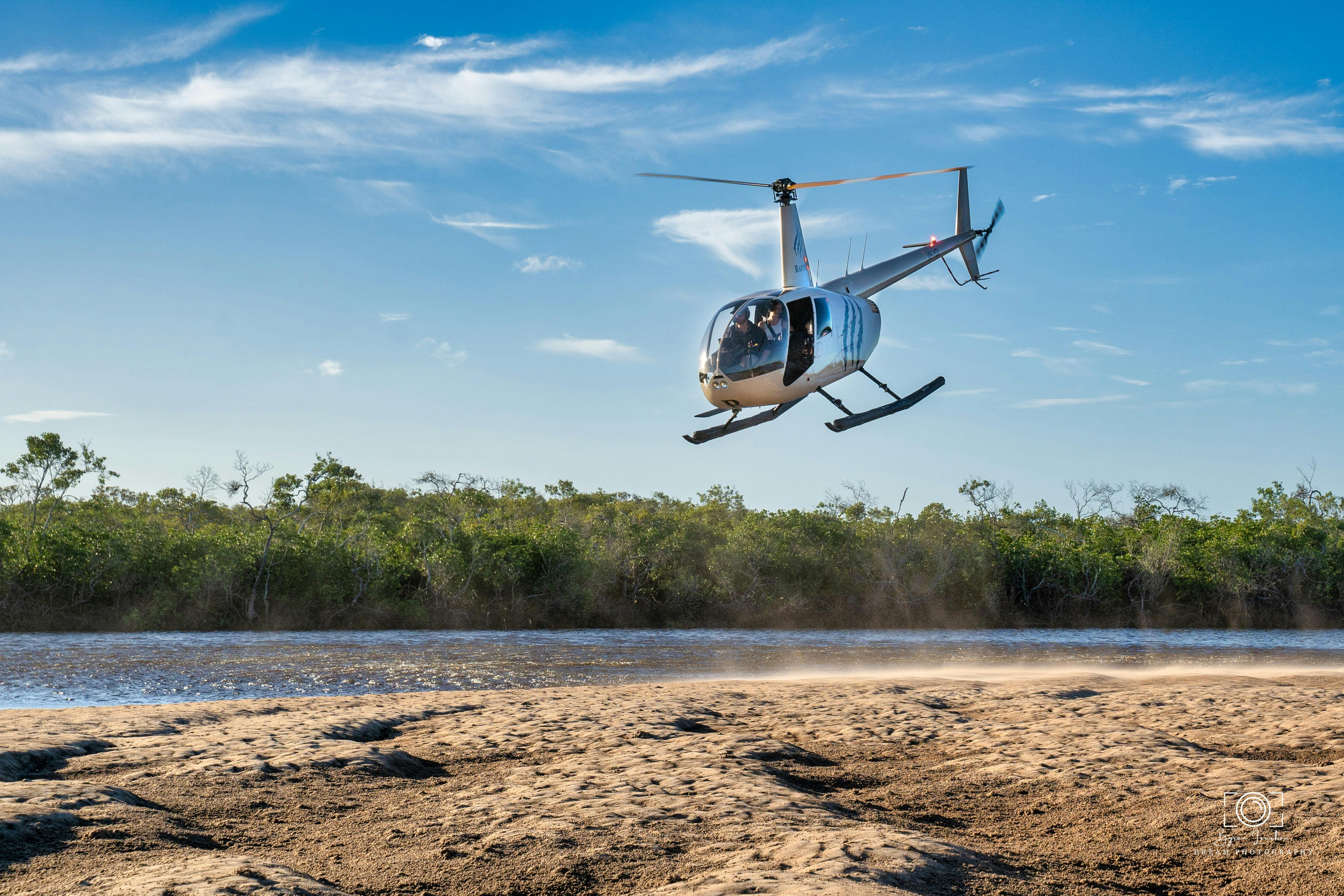 the helicopter is coming to land from Mangrove to Beach and stunning colours of greens and blues