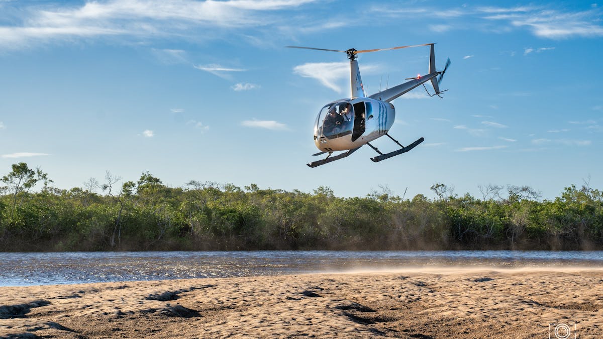 the helicopter is coming to land from Mangrove to Beach and stunning colours of greens and blues