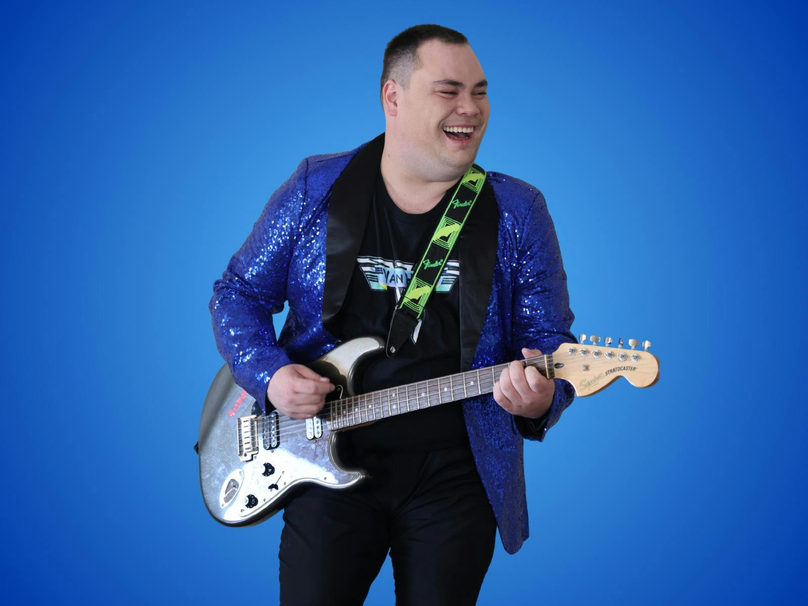 Robbie Hart with his electric guitar wearing a sparkling purple and black jacket
