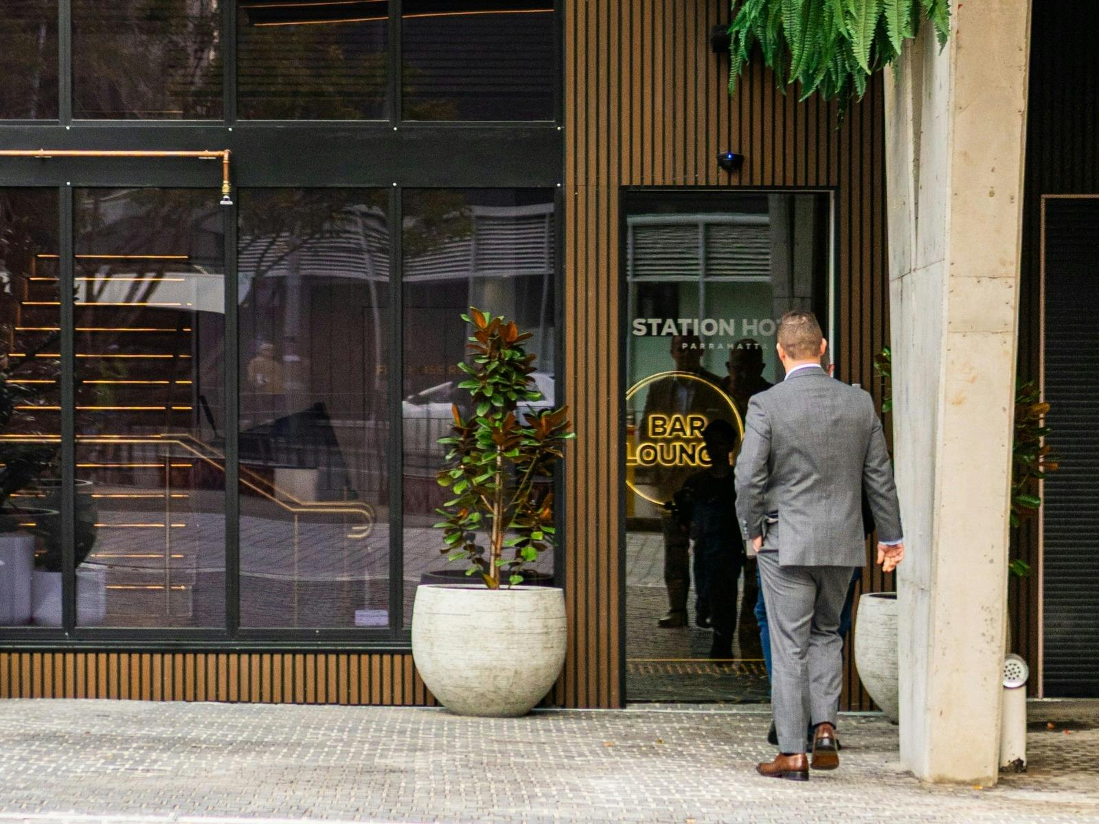 exterior of the building with male in a suit walking in