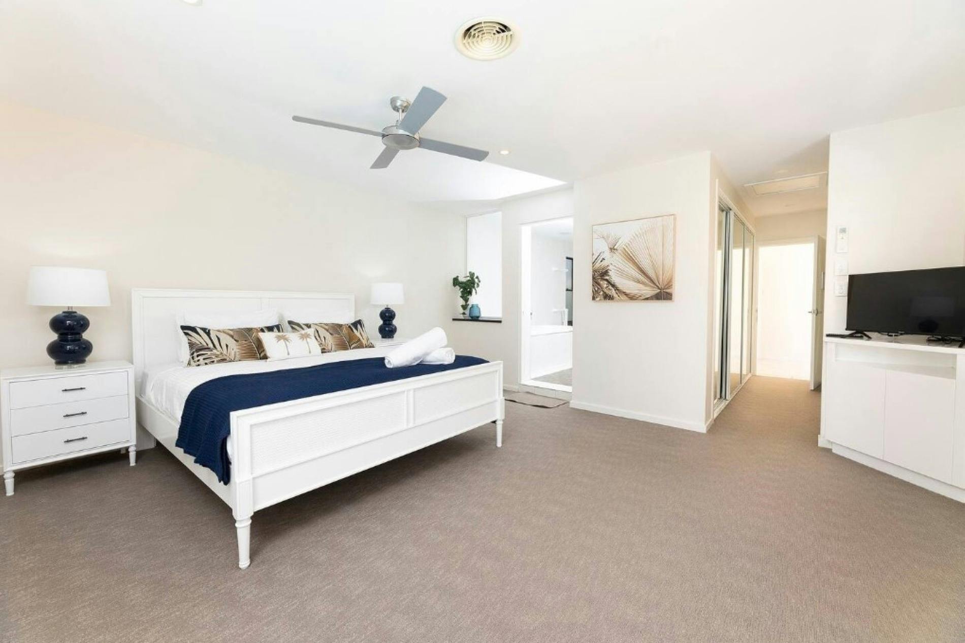 TV와 천장형 선풍기가 있는 침실