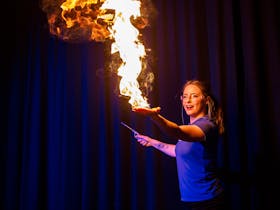 Science presenter demonstrating hand on fire.