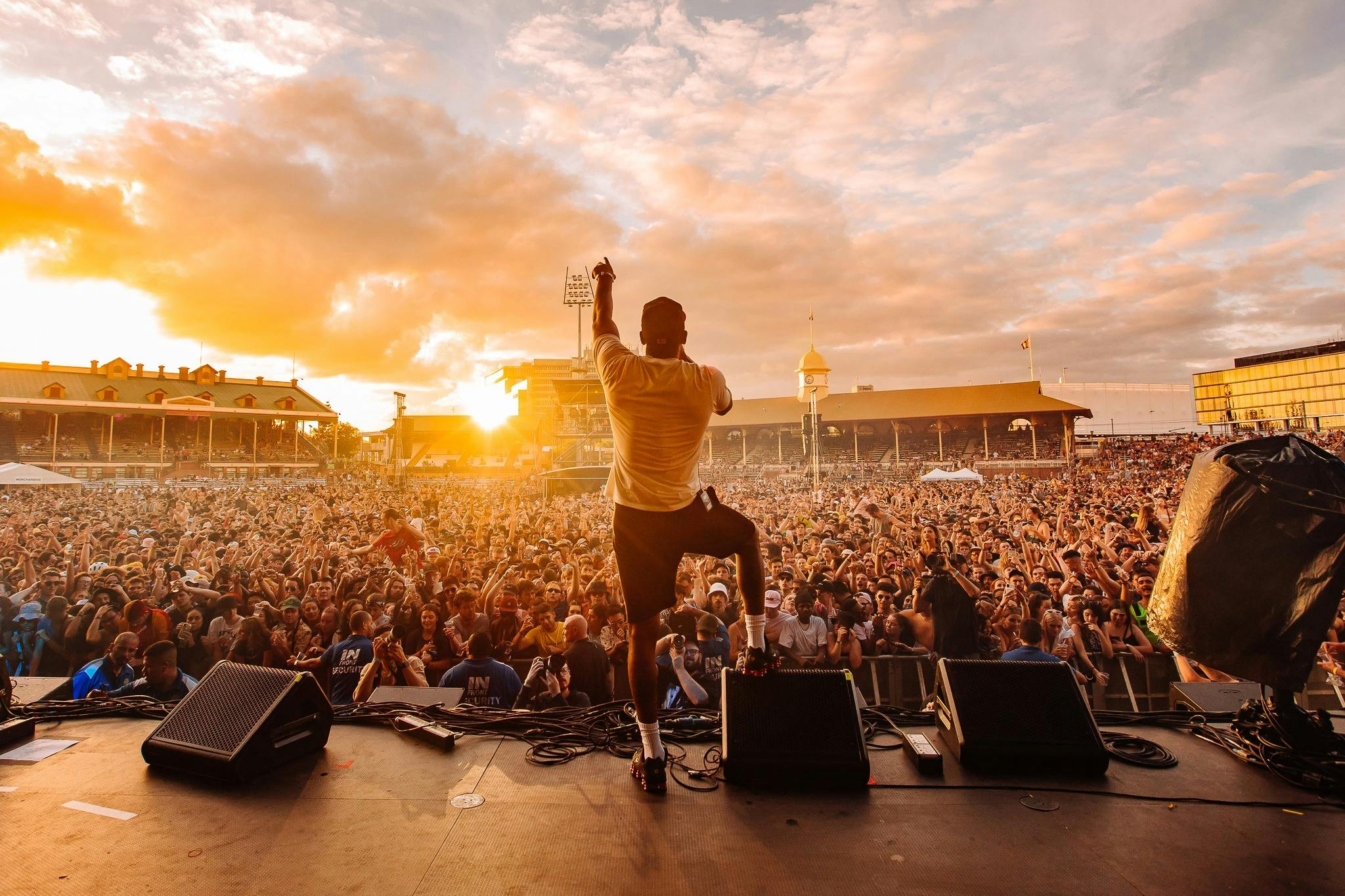 Artist on stage in foreground pointing to crowd at Wildlands 2021