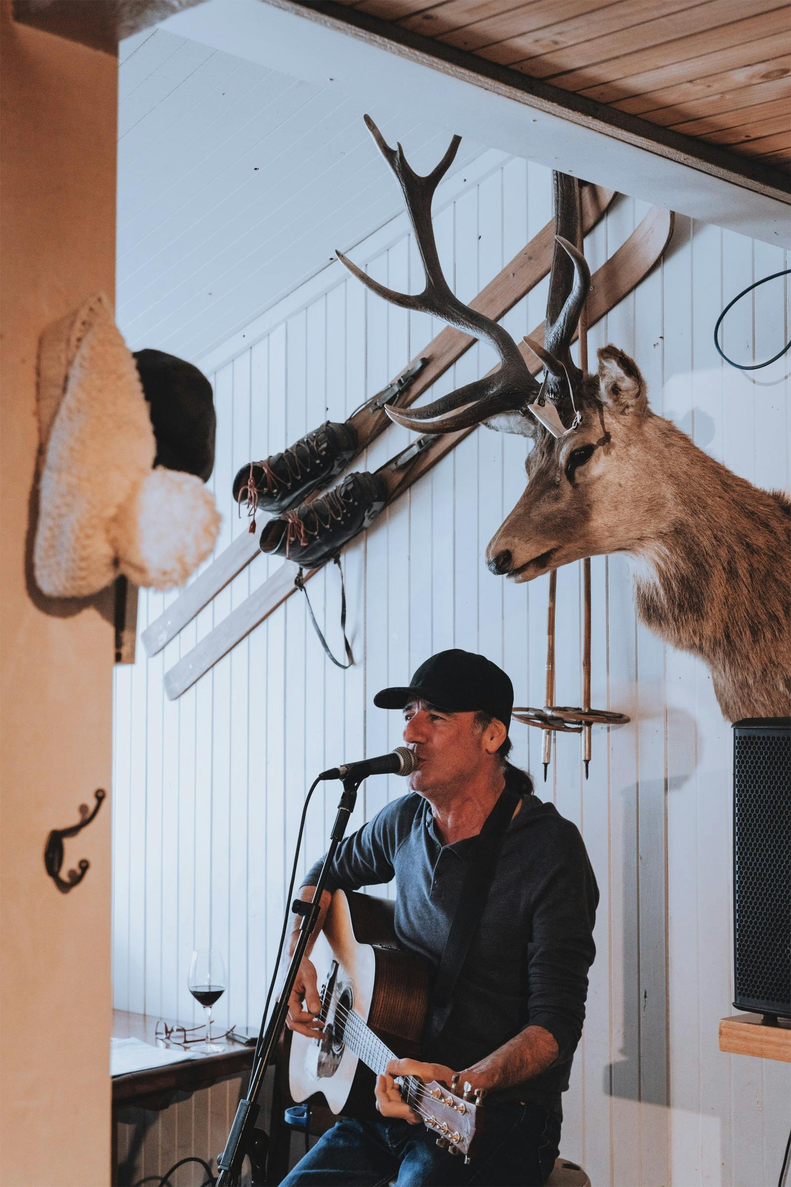 Musician playing guitar at Feathertop Lodge during weekly live music nights, cosy fireside atmospher