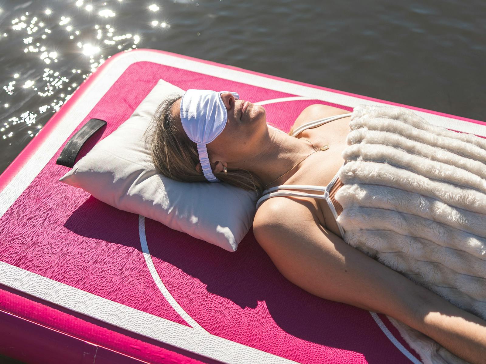 lady lying on floating device board with eye mask on