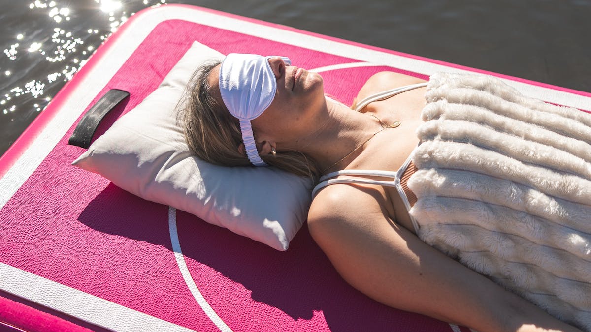 lady lying on floating device board with eye mask on
