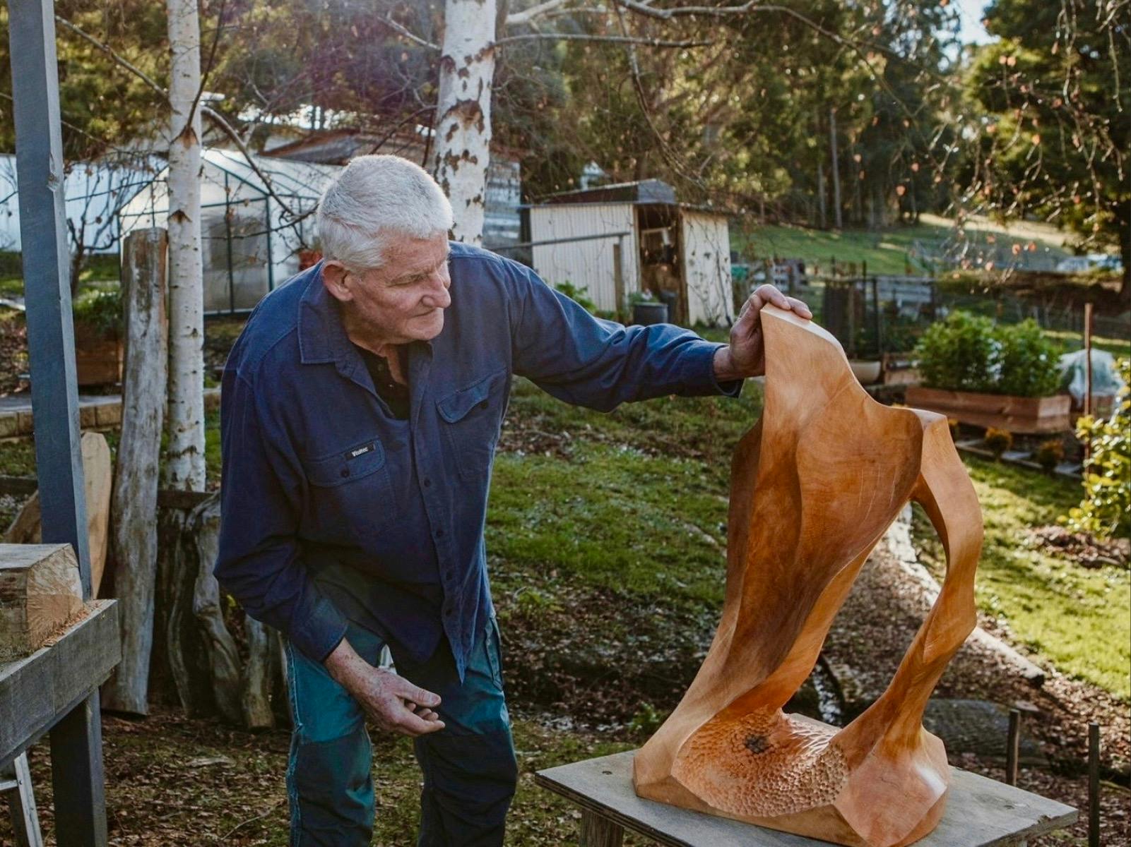 A wood sculpture stands next to his sculpture out of Huon Pine