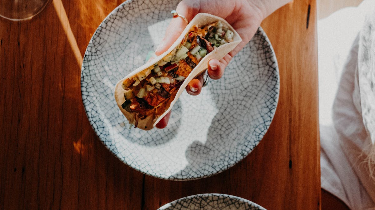 Happy woman holding a delicious taco.