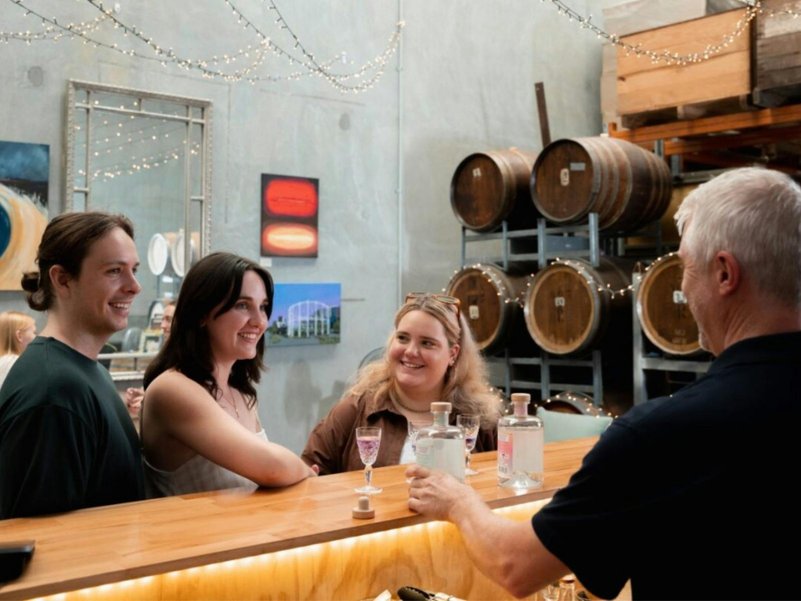 People tasting gin at the bar with the chrief distiller People tasting gin at the bar with the chrief distiller