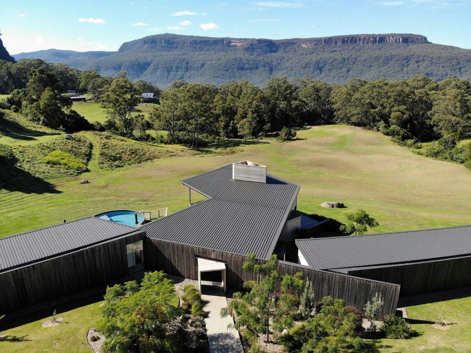 Image of aerial view of top of property backdrop of mountain escarpment and bushland
