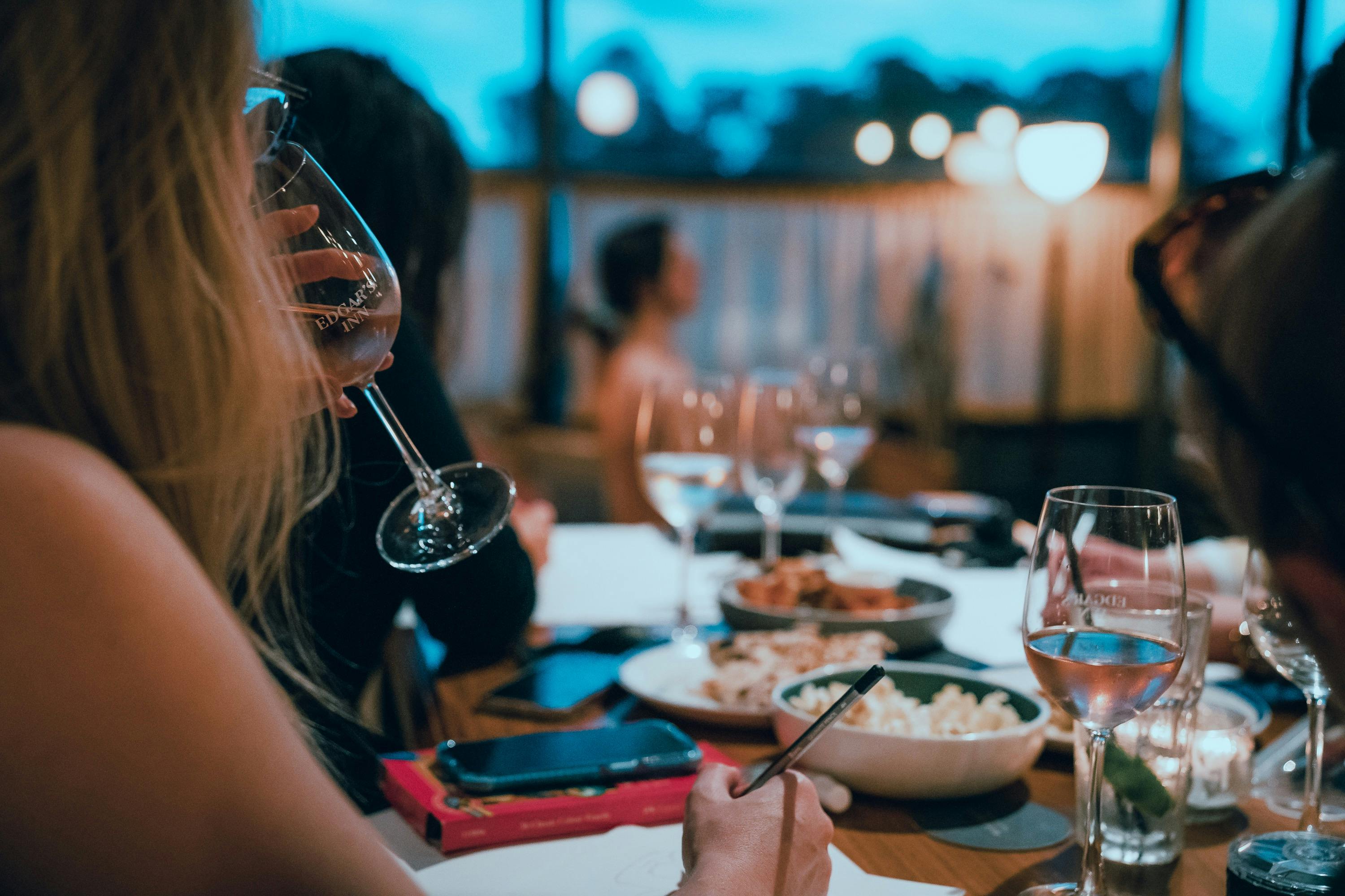 Woman drinking sparkling wine with art model sitting in background