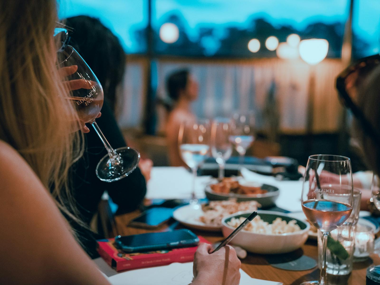 背景に座っている芸術モデルとスパークリング ワインを飲む女性