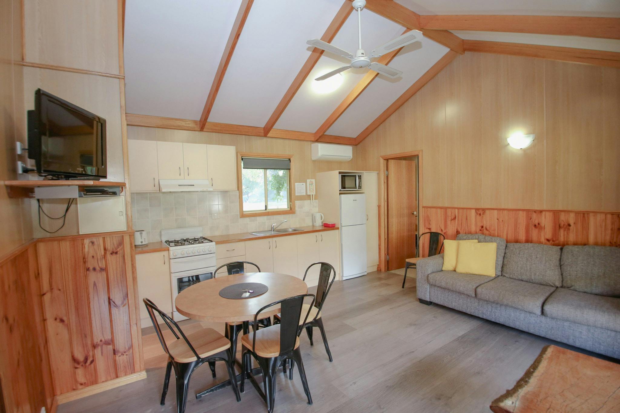 image of living room inside cabin with dining table, couch and kitchen