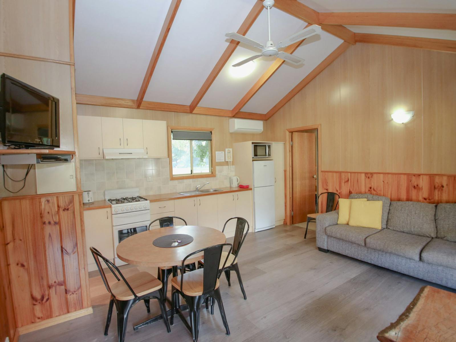 image of living room inside cabin with dining table, couch and kitchen