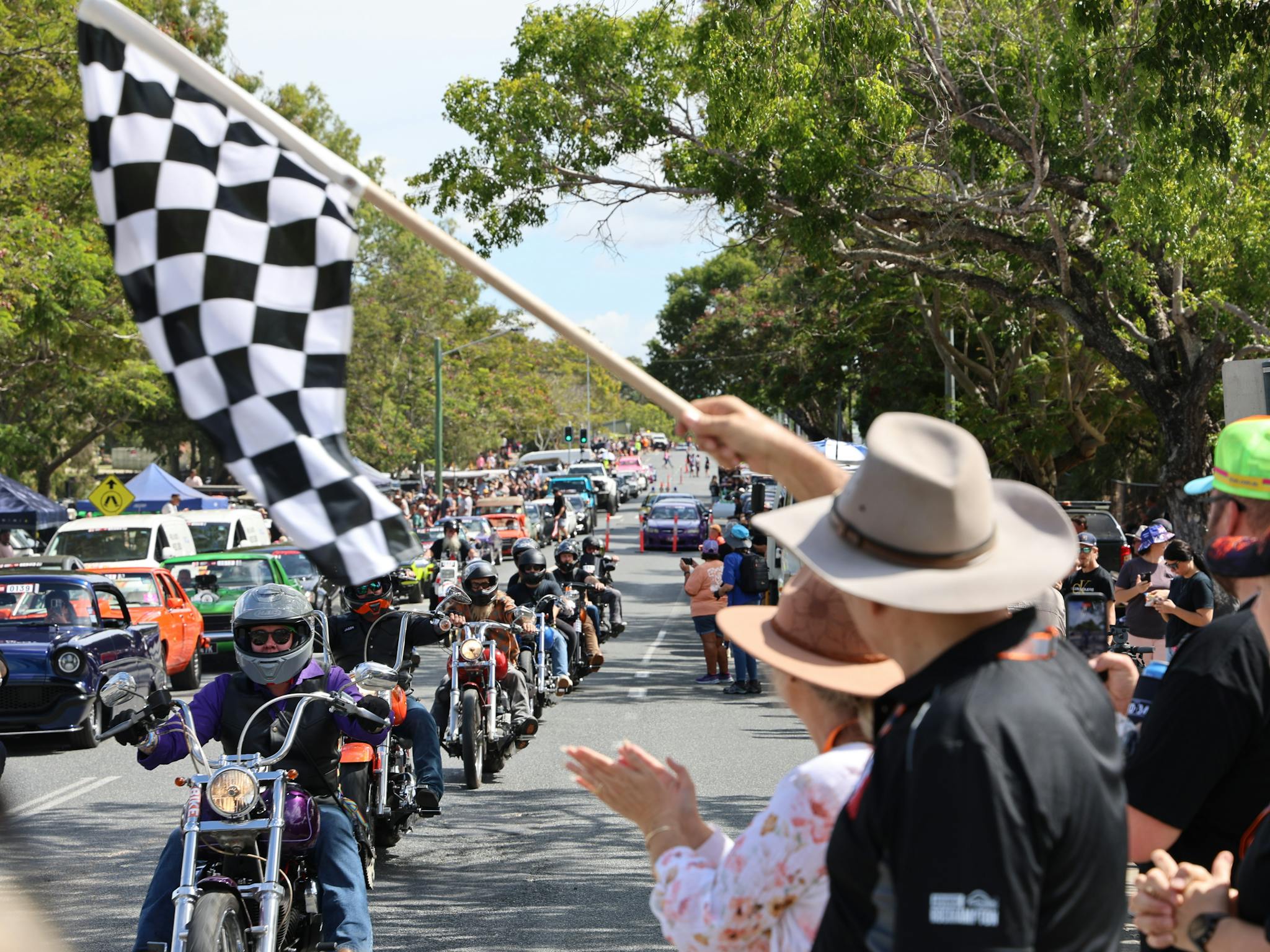 Motorcycles and cars in a street parade watched by crowds during Rockynats. Motorcycles and cars in a street parade watched by crowds during Rockynats.