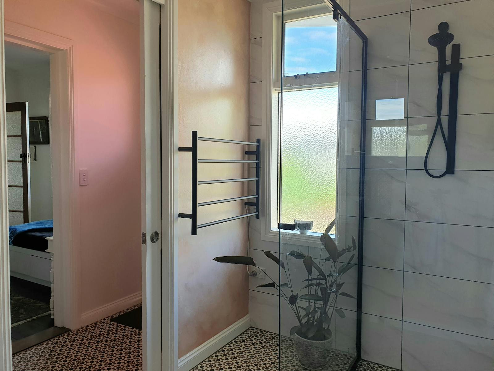 Tiled entrane hall and bathroom showing shower and heated towel rail