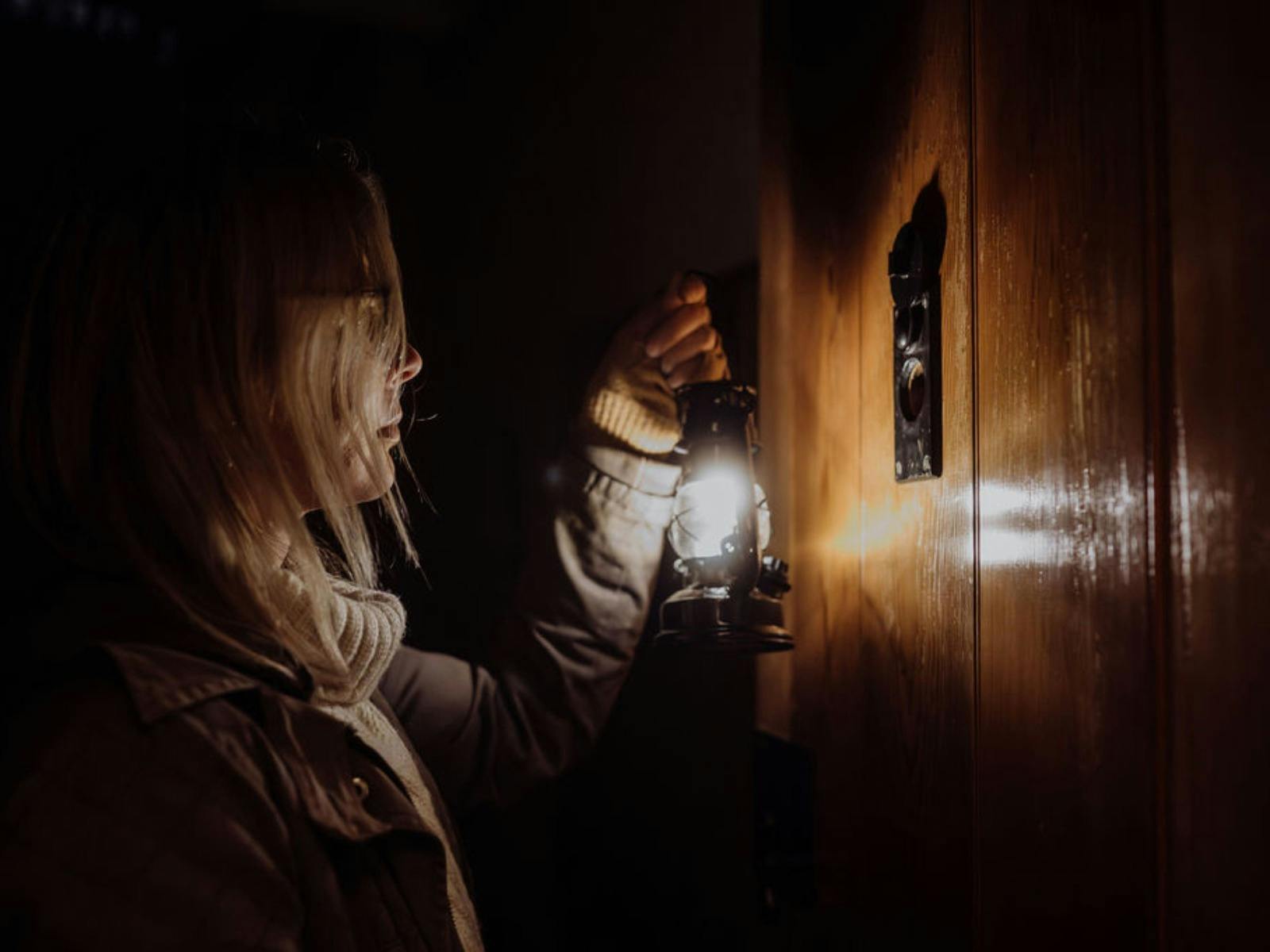 Guest looking through peep hole of Military Gaol Door