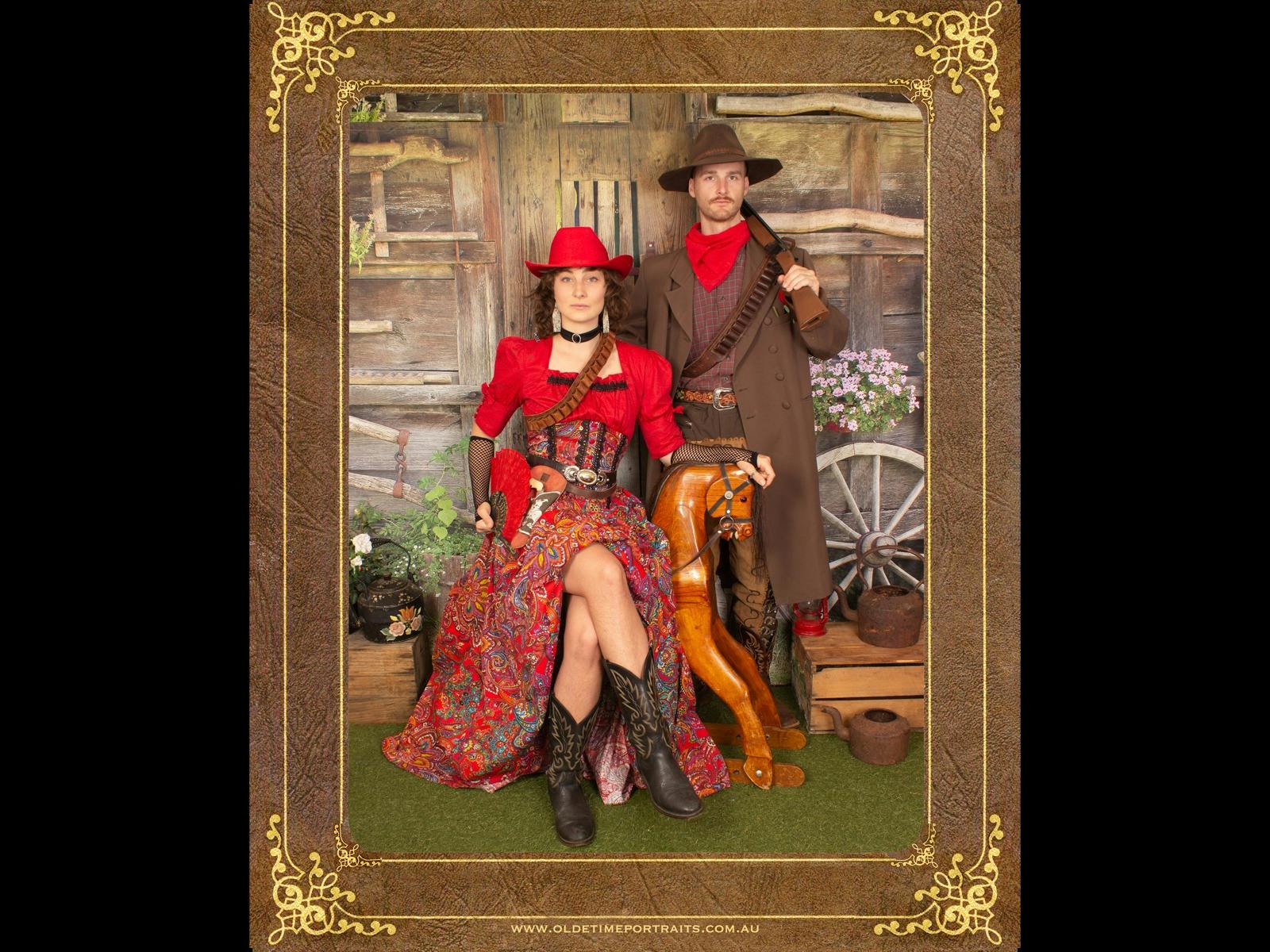 a couple dressed in western costumes with old Pickers Hut in background