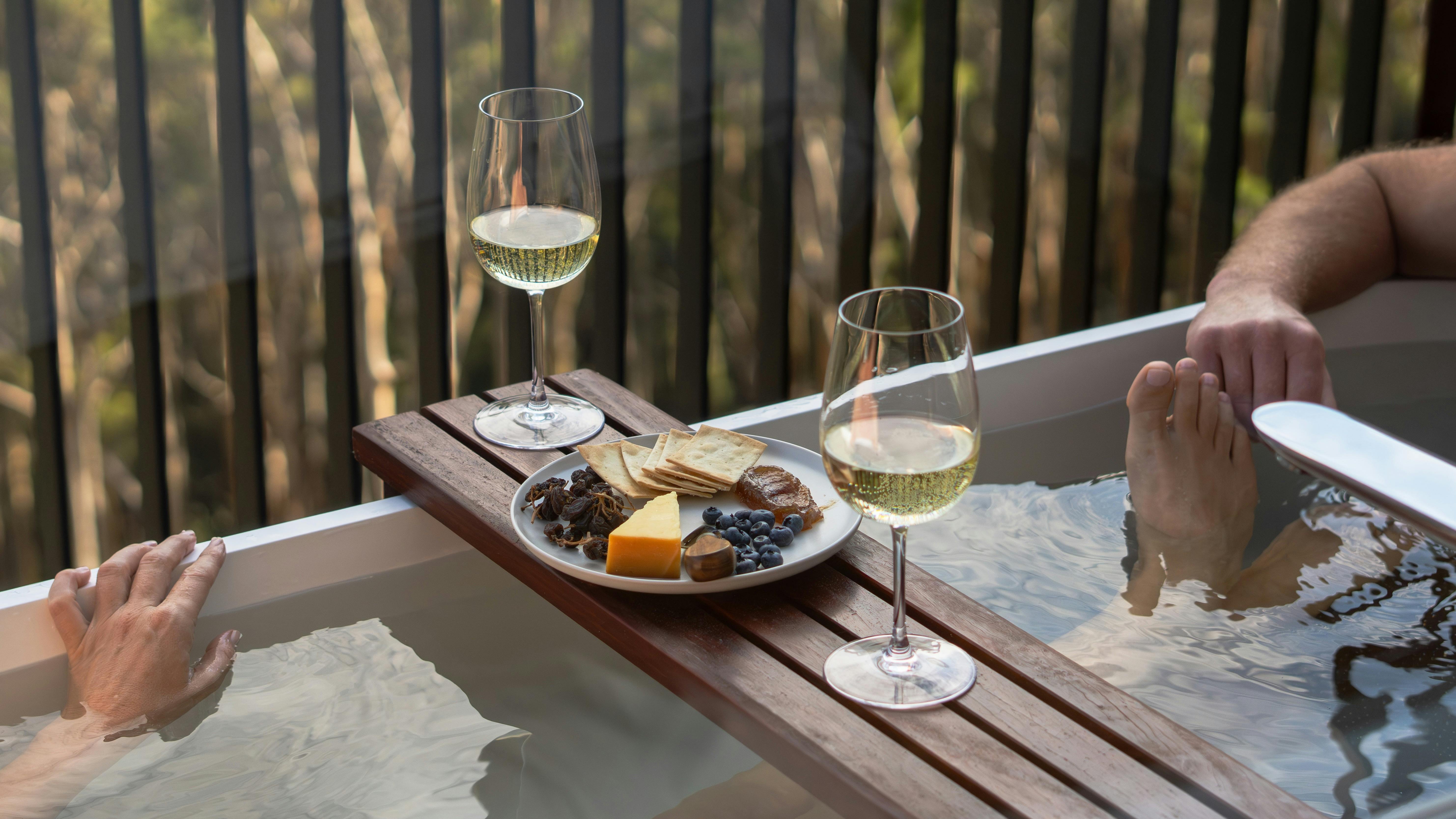 Outdoor bath on a deck with wine and cheese board