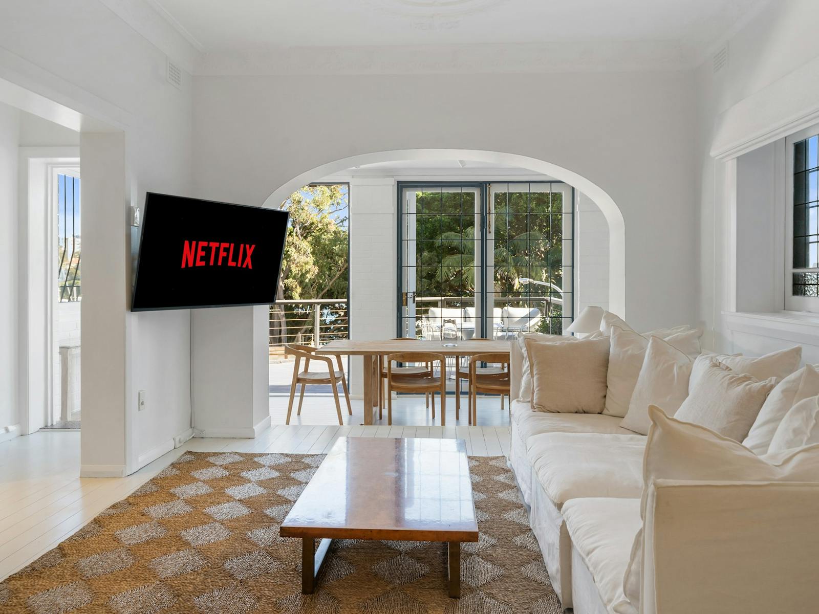 Living room with cozy sofa and dining area with outdoor balcony access.