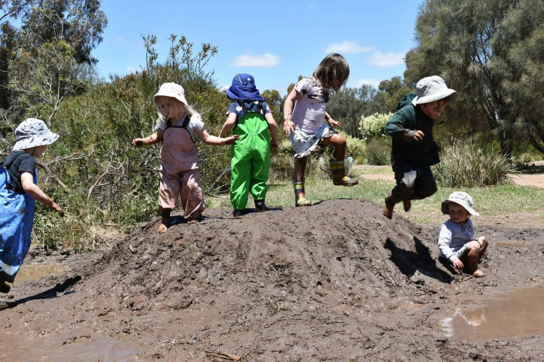 Children playing on mud heap