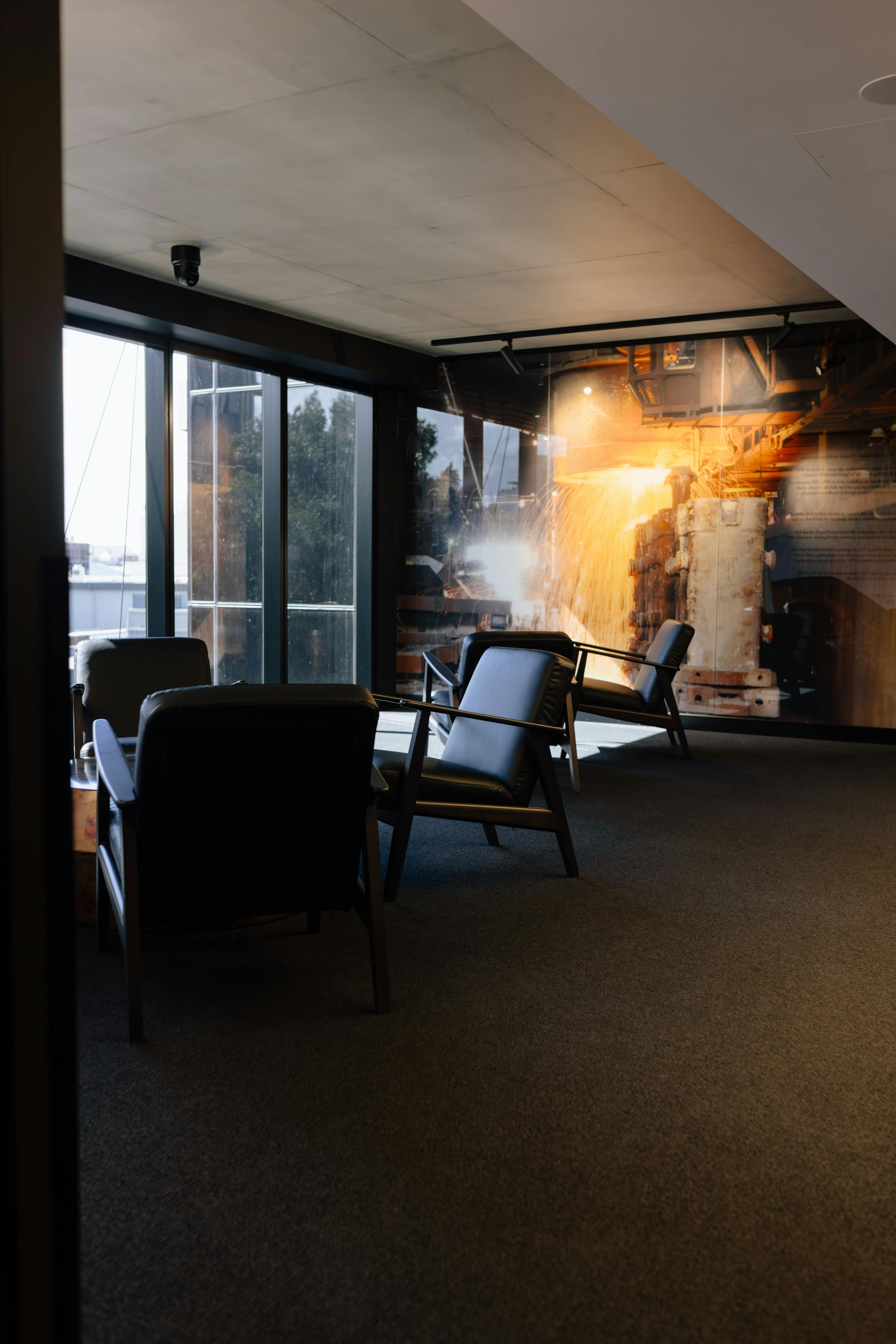 Modern lobby seating area with leather seats, a coffee table, and natural light